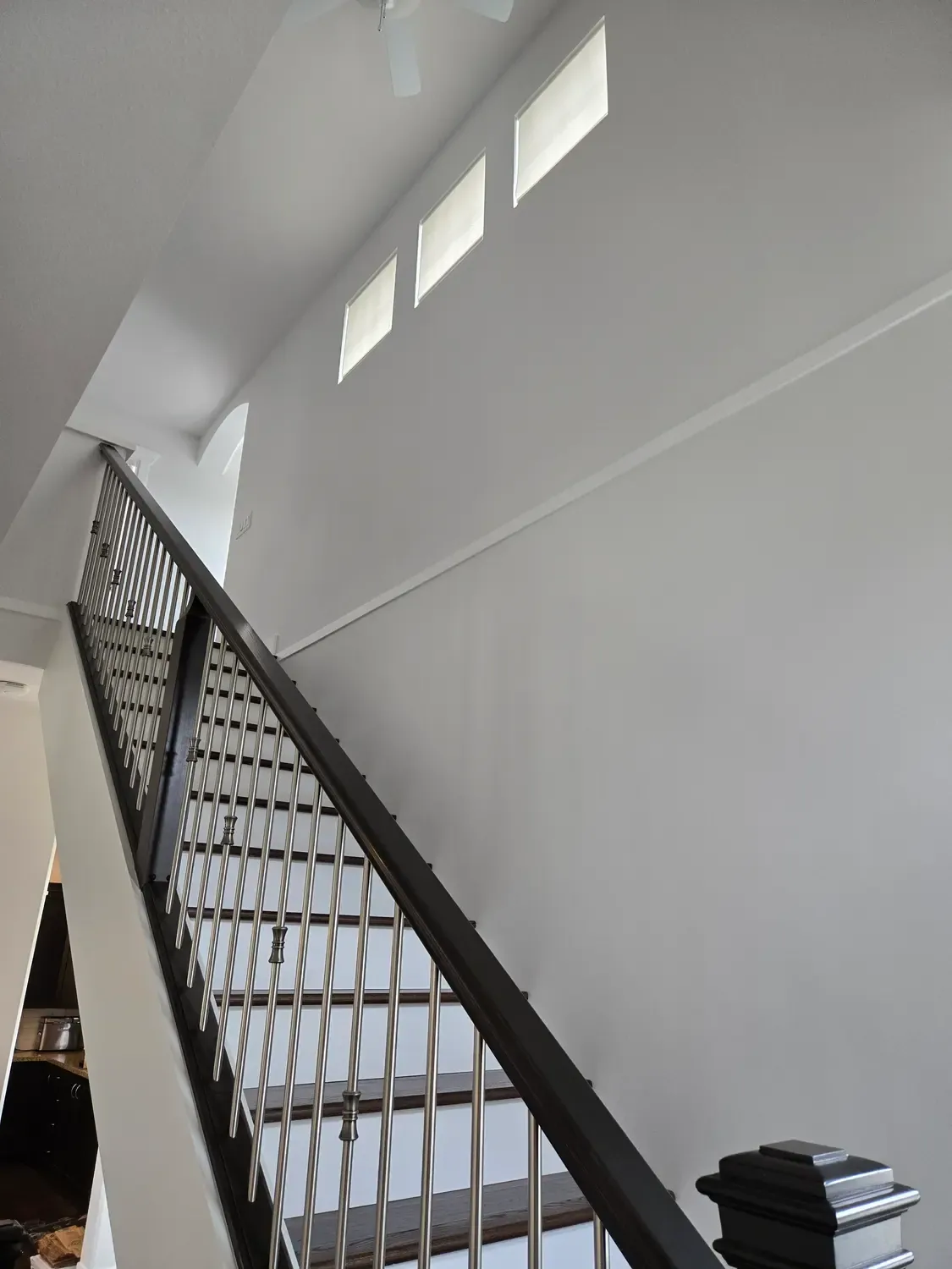 Freshly painted white stairwell with a black railing