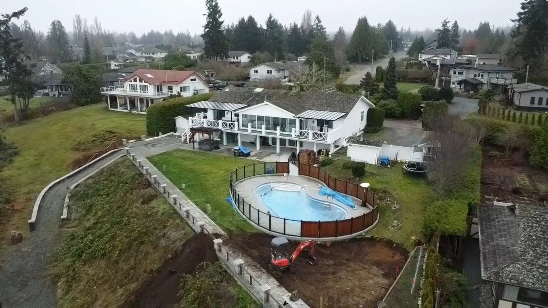 Aerial photo of a house with a pool and landscaped yard