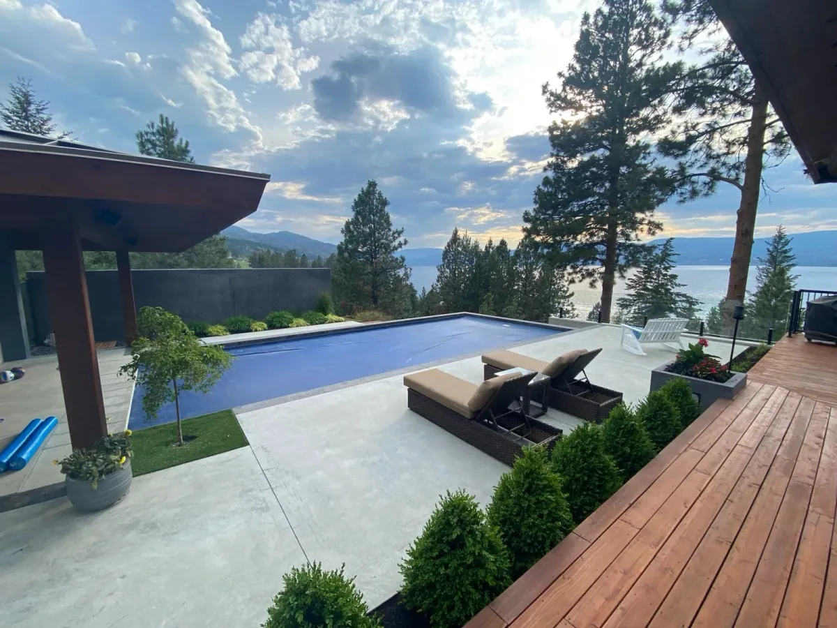 A backyard pool with Okanagan Lake and the hills behind