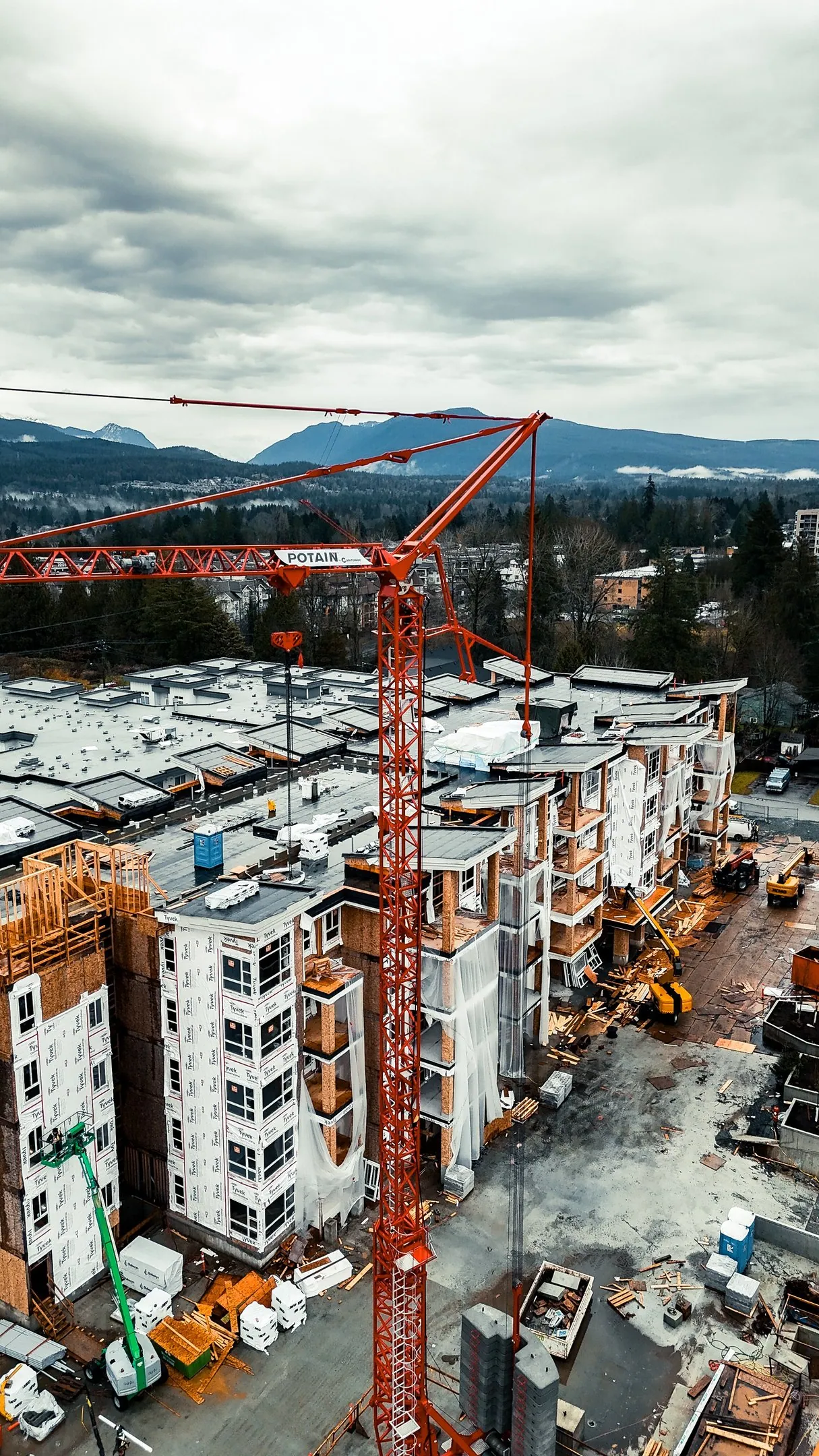 Aerial view of a multi-storey construction site with a tower crane