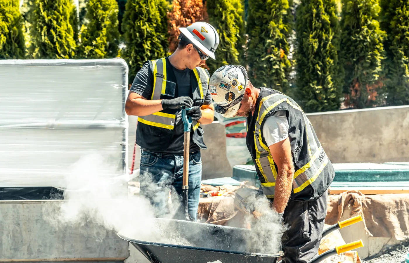 Two contractors mixing concrete on a sunny job site